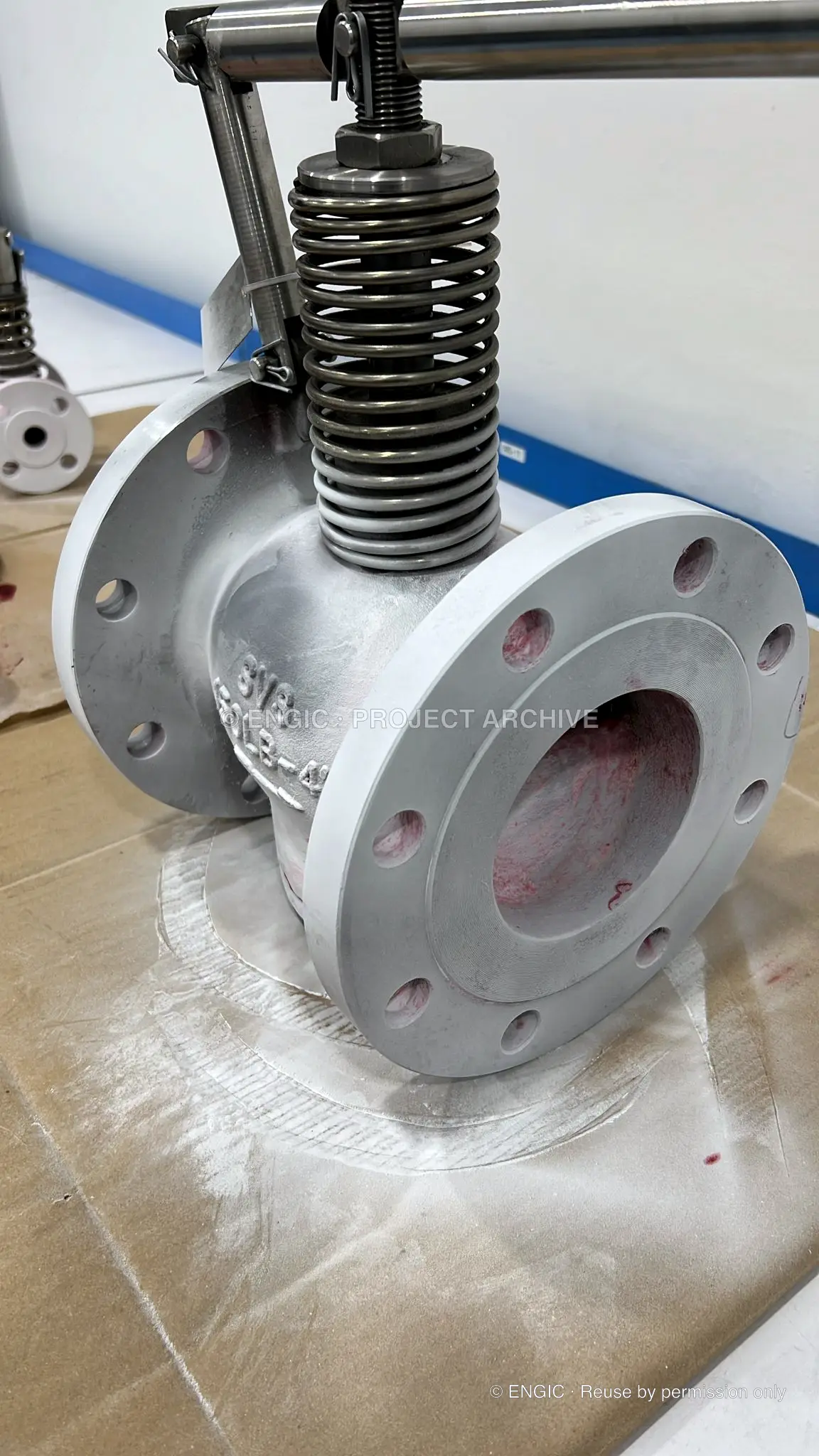 Valve flange and body under examination during visible dye penetrant testing