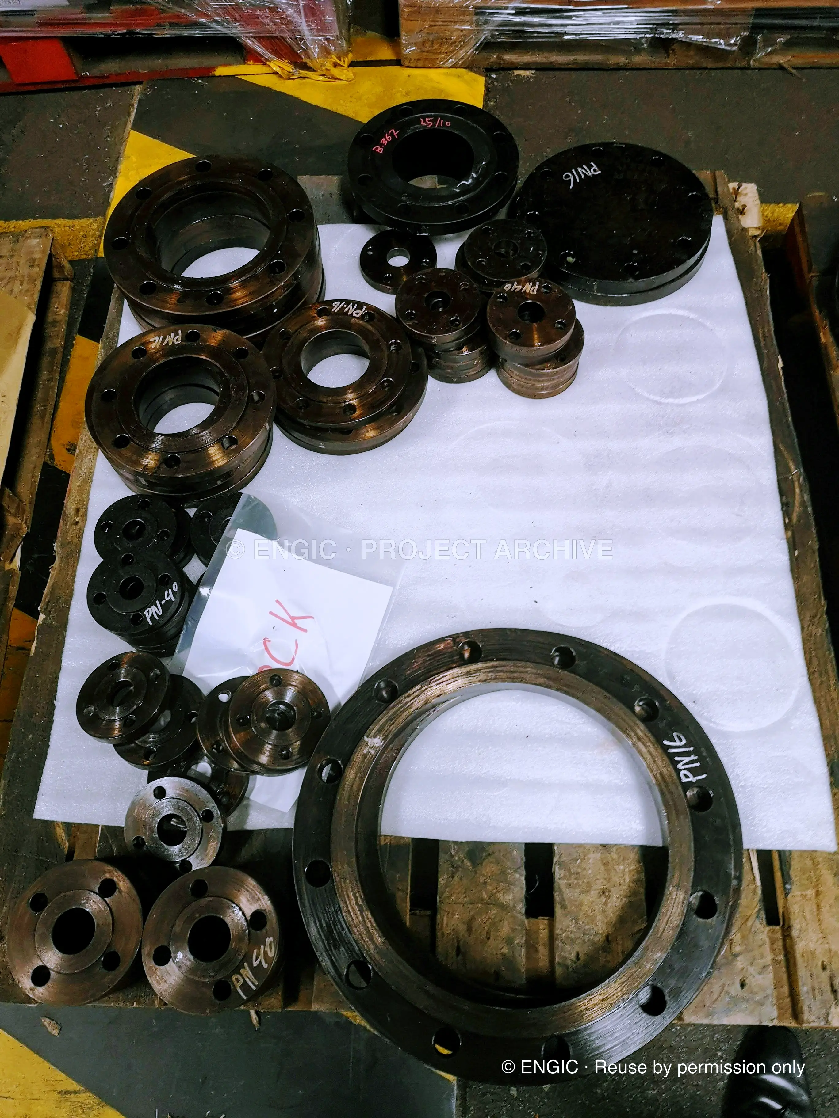 Bronze flanges and gaskets laid out on a white sheet for checking