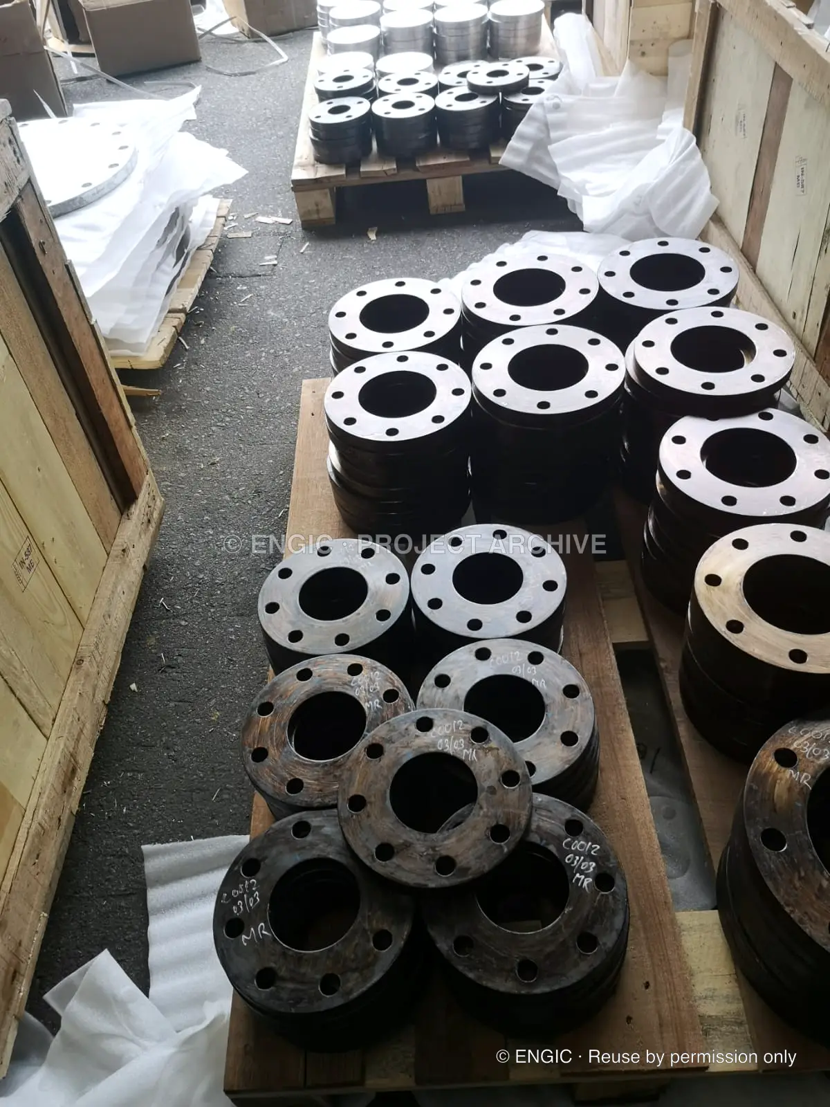 Stacks of machined flanges arranged between timber cases before packing