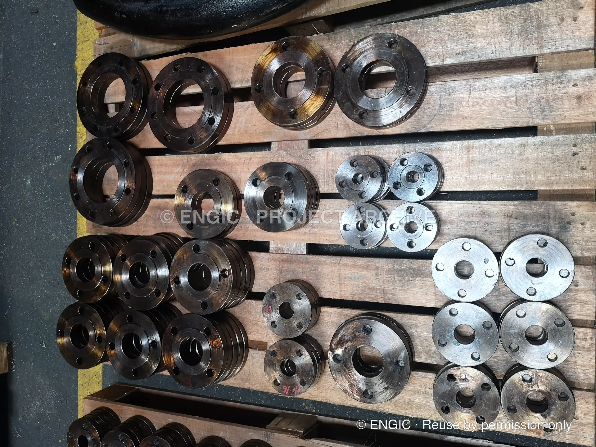 Flanges of different diameters and finishes arranged on a timber pallet