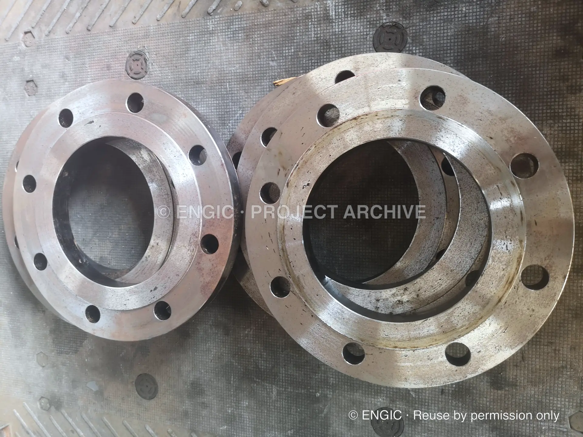 Four raised-face flanges grouped together on a workshop floor