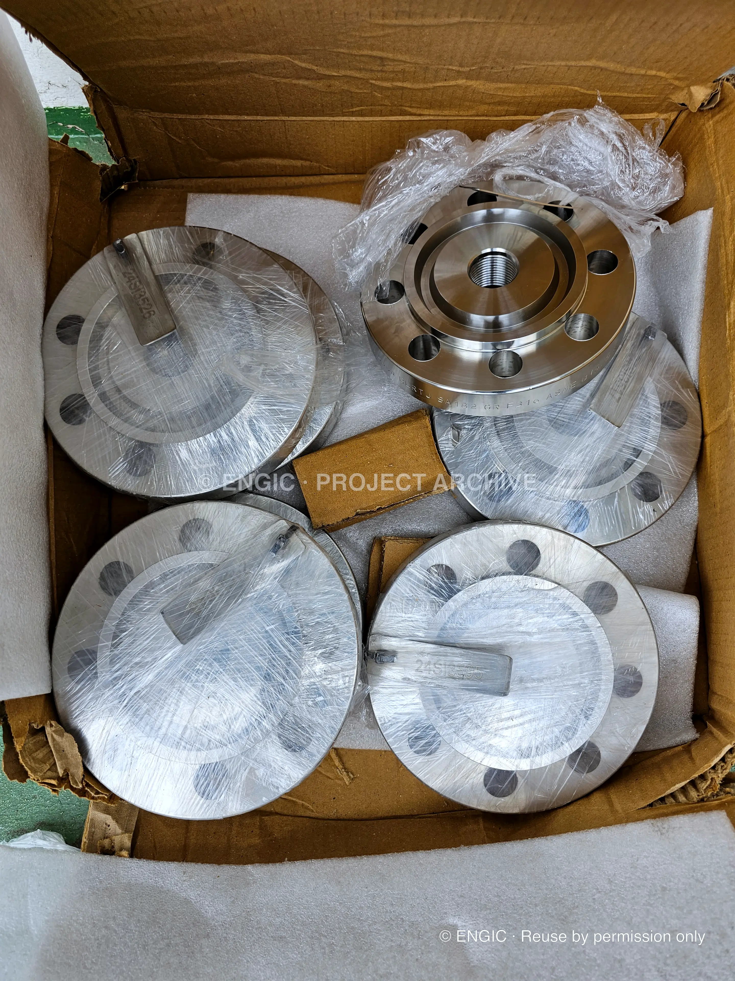 Assorted stainless blind and weld neck flanges on a pallet