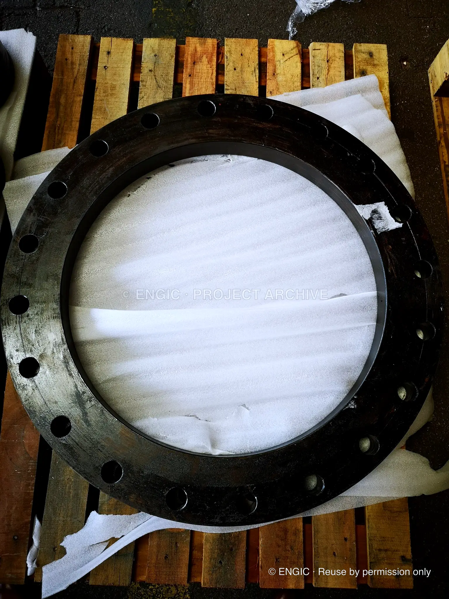 A large flange with its bore covered and protected on a pallet