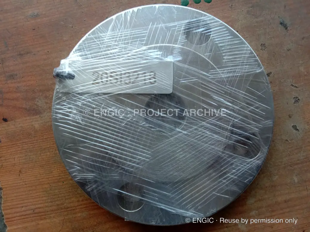 A circular machined component protected with clear wrapping