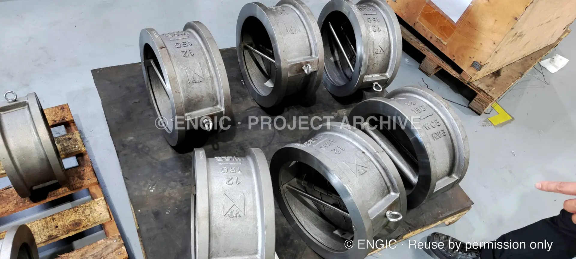 Several machined valve bodies arranged together on a workshop bench