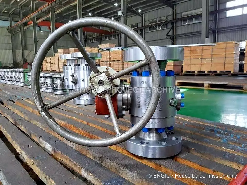 A large handwheel and valve assembly on a workshop bench
