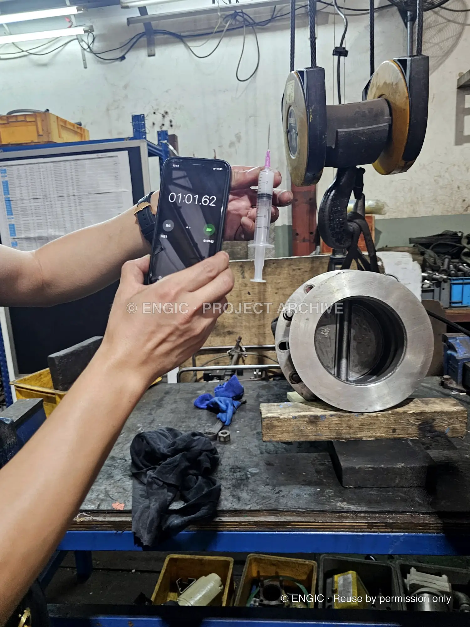 A technician checking a valve body with a handheld measuring instrument
